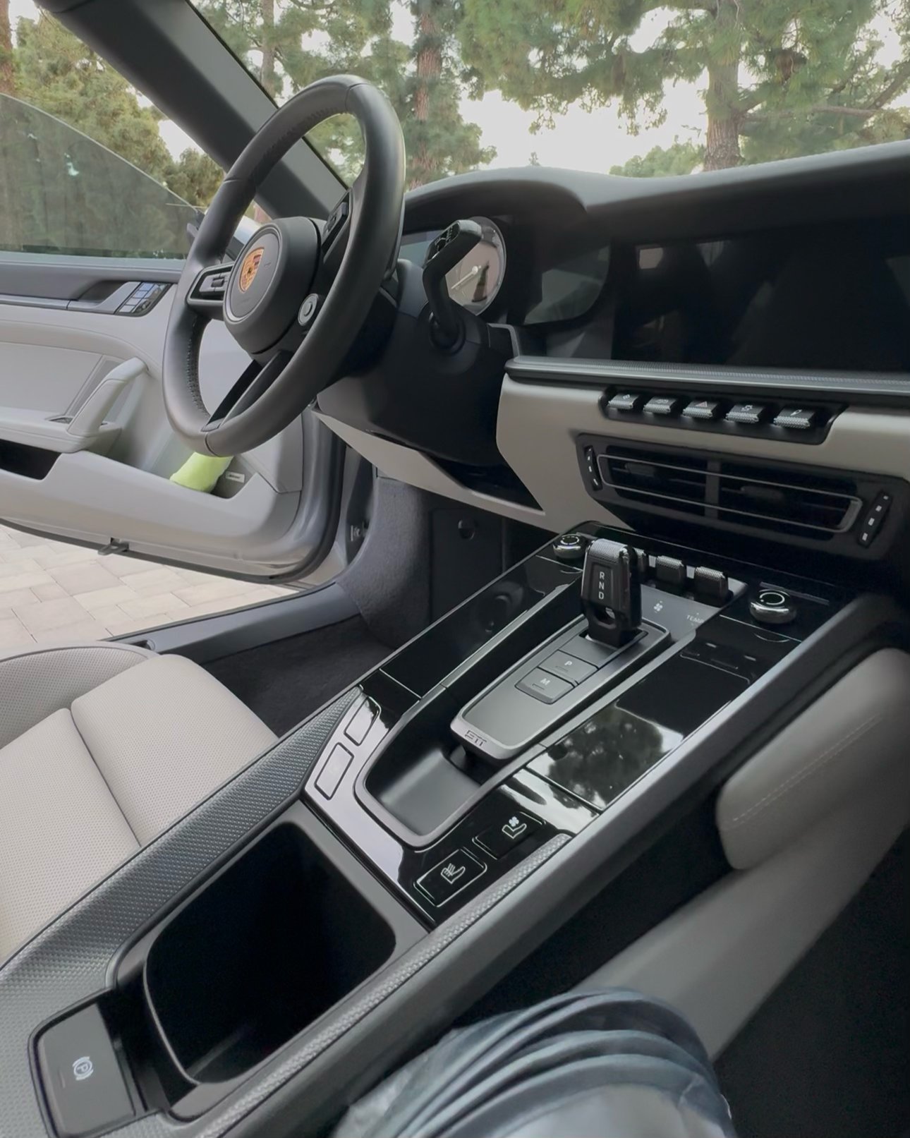 Interior view of a luxury sports car showing the steering wheel, dashboard, and center console with control buttons and air vents.